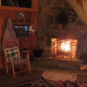 a stone fireplace in a room with a rocking chair at Buckberry Creek Chalet in Gatlinburg