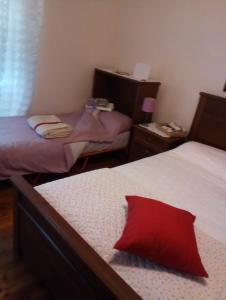 sypialnia z 2 łóżkami i czerwoną poduszką na łóżku w obiekcie Casa Vacanze Poison w Trieście +10 zdjęć