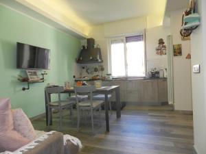 sala de estar con mesa y cocina en Casa Sissi, en Albisola Superiore