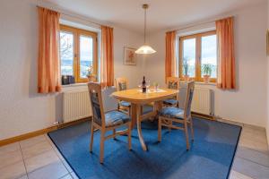 a dining room with a table and chairs and windows at Ferienwohnung Lex in Bad Griesbach +22 photos