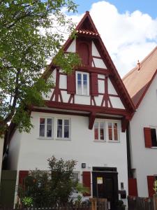 een wit huis met een gambrel dak bij Ferienwohnung Eulenloch in Nördlingen