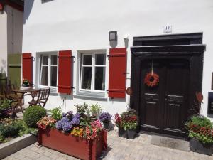 a house with flowers in front of a door at Ferienwohnung Eulenloch in Nördlingen