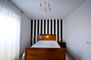 ein Schlafzimmer mit einem Holzbett und einem Kronleuchter in der Unterkunft Casa Annunziata, Borgo e mare a Badolato in Badolato