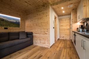 Una sala de estar con un sofá y una cocina. en Lüch dl Cajer - Appartement Col, en San Martino in Badia 5 fotos más