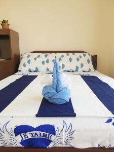 Una cama con una toalla azul encima. en R & D Island Lodge, en Bantayan Island
