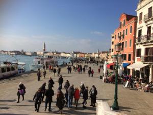 a group of people walking on a street near the water at Cà Grandi in Venice