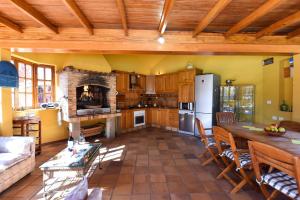 eine große Küche mit einem Tisch und einem Kühlschrank in der Unterkunft Finca Madroñal with Pool in Gran Canaria in Santa Brígida