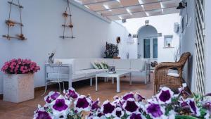 a living room with a white couch and purple flowers at Nonna Mina in Felline