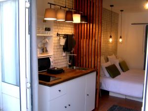a kitchen with a sink and a bed in a room at Small Loft in Cascais