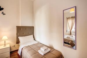a small bedroom with a bed and a mirror at Aura Paradise Apartment in Rome
