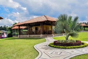 a gazebo with a palm tree in a park at La Victoria Hotel Campestre in Quimbaya