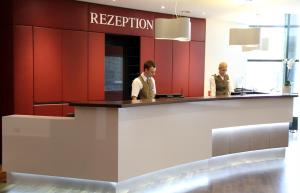 two men standing at a reception counter in a restaurant at Steigenberger Dortmund in Dortmund