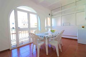 a dining room with a table and chairs and a kitchen at Migjorn 2 2 Roses - Immo Barneda in Roses