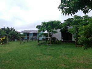 a house with a yard in front of it at Casa de Praia, baixo custo e boa localização in Xangri-lá