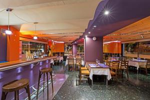 a restaurant with purple walls and tables and chairs at Hotel Avenida in La Seu d'Urgell