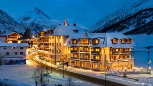 un hotel en la nieve por la noche con montañas en Alpenresort Fluchthorn, en Galtür