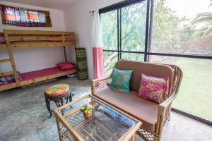 a living room with a couch and a bunk bed at Phor Kub Mae Homestay in Damnoen Saduak