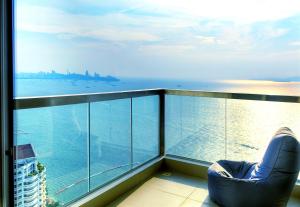 a chair on a balcony looking out at the ocean at Lux SL Luxury Style of Life 5 in Pattaya North