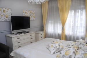 a bedroom with a bed with a television on a dresser at My Home, with free secure parking in Stara Zagora