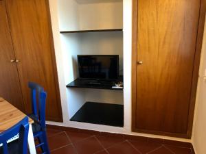 - un salon avec une télévision dans une étagère intégrée dans l'établissement La Casa di Dory, à Gênes