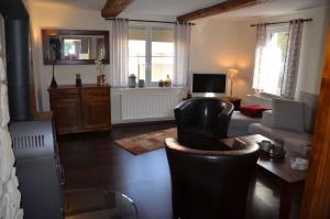 a living room with a couch and a chair and a television at Ferienhaus Spreewiese in Schlepzig