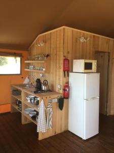 een keuken met een witte koelkast en een magnetron bij Quinta O Ninho in Monchique
