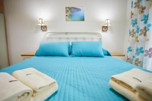 a blue bed with two towels on top of it at Chioni's Houses in Chios
