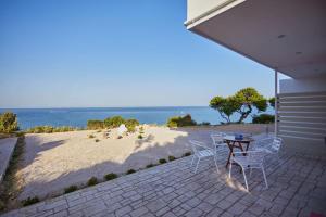 um pátio com uma mesa e cadeiras e uma praia em Chioni's Houses em Quios