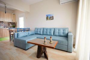 a living room with a blue couch and a table at Chioni's Houses in Chios