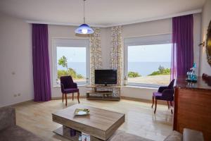 a living room with a tv and two windows at Chioni's Houses in Chios