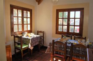 ein Esszimmer mit 2 Tischen und 2 Fenstern in der Unterkunft Laguna Esmeralda B&B in Ushuaia