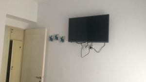 a flat screen tv hanging on a wall at Departamento Cabo Corrientes con cochera cubierta in Mar del Plata