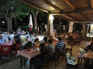 a group of people sitting at tables in a restaurant at Bolsena Holiday House in Bolsena