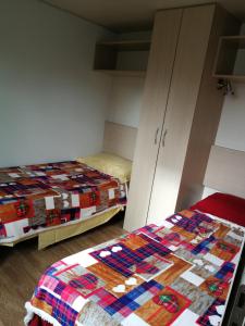 a bedroom with two beds and a quilt at Bolsena Holiday House in Bolsena