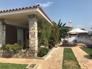 a stone house with a patio and an umbrella at Villa Juani in Vinarós