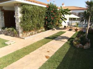 a garden with a house with a hedge and grass at Villa Juani in Vinarós