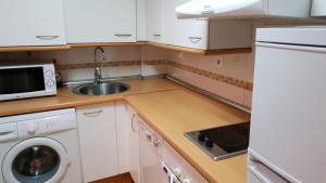 una pequeña cocina con fregadero y microondas en Madrid Airport Apartments, en Madrid