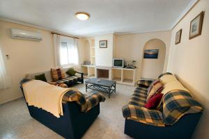 a living room with two couches and a table at Villa Isabel in Murcia