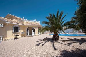 a large house with a palm tree in front of it at Villa Isabel in Murcia