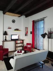 ヴィルフランシュ・ド・ルエルグにあるLa Perle du Rouergueのリビングルーム(白いソファ、赤い椅子付)