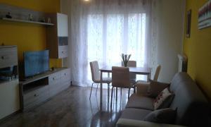ein Wohnzimmer mit einem Sofa, einem Tisch und einem TV in der Unterkunft CASA FEDERICA in Marghera