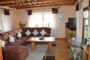 a living room with a brown couch and a coffee table at Ferienwohnung Selbitschka in Kirchberg