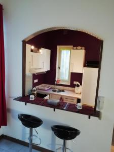 - une petite cuisine avec un miroir mural dans l'établissement La Perle du Rouergue, à Villefranche-de-Rouergue