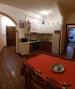 una cucina con tavolo al centro di una stanza di AndEli ad Alghero