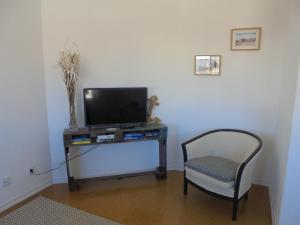a room with a chair and a television on a table at BeachCity Guesthouse in Lagos