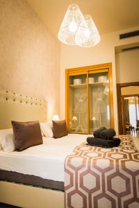 a bedroom with a large bed and a chandelier at Holidays2Malaga junto Catedral in Málaga