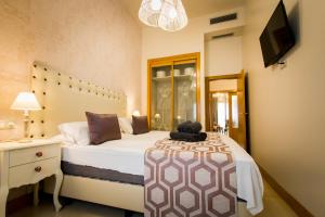 een slaapkamer met een bed, een dressoir en een televisie bij Holidays2Malaga junto Catedral in Málaga