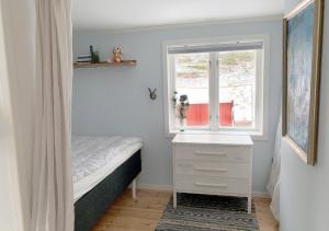 a small bedroom with a bed and a window at 18th century farm cottage in Valdemarsvik