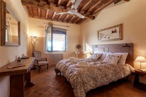 a bedroom with a large bed with a desk and a chair at La Casa di Thea in Impruneta