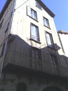 ヴィルフランシュ・ド・ルエルグにあるLa Perle du Rouergueの窓とバルコニー付きの高層ビル